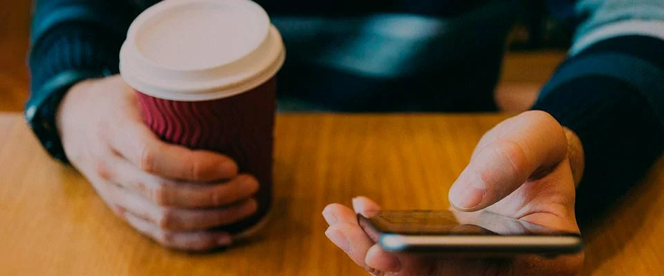 Foto vista superior chico con vaso café y móvil