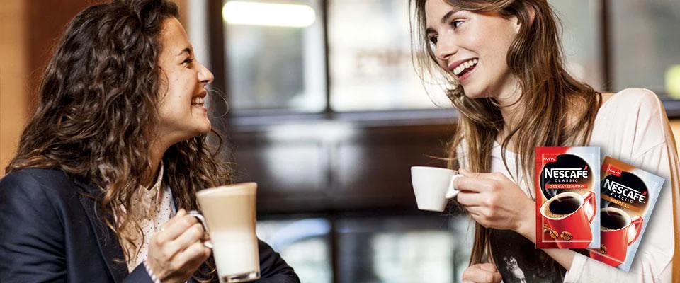 Foto chicas sonriendo con sobres de Nescafé