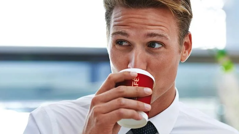 Foto ejecutivo tomando café en oficina