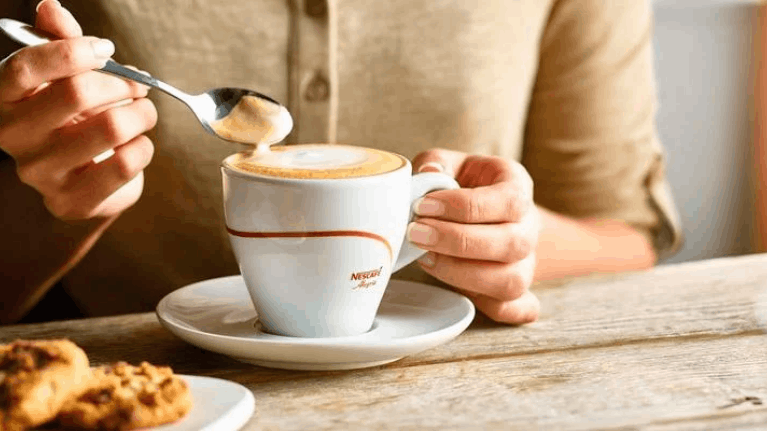 cliente bebiendo un café de maquinas de café nescafé alegria