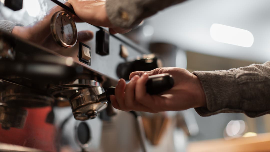 Camarero preparando café en una cafetera profesional