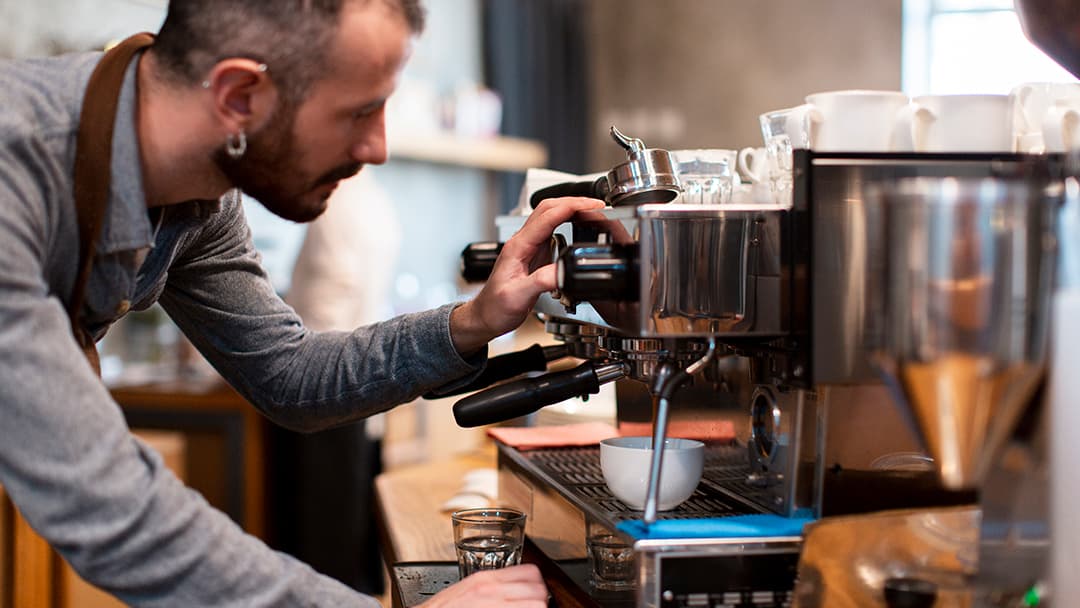 Camarero elaborando un café en máquina profesional