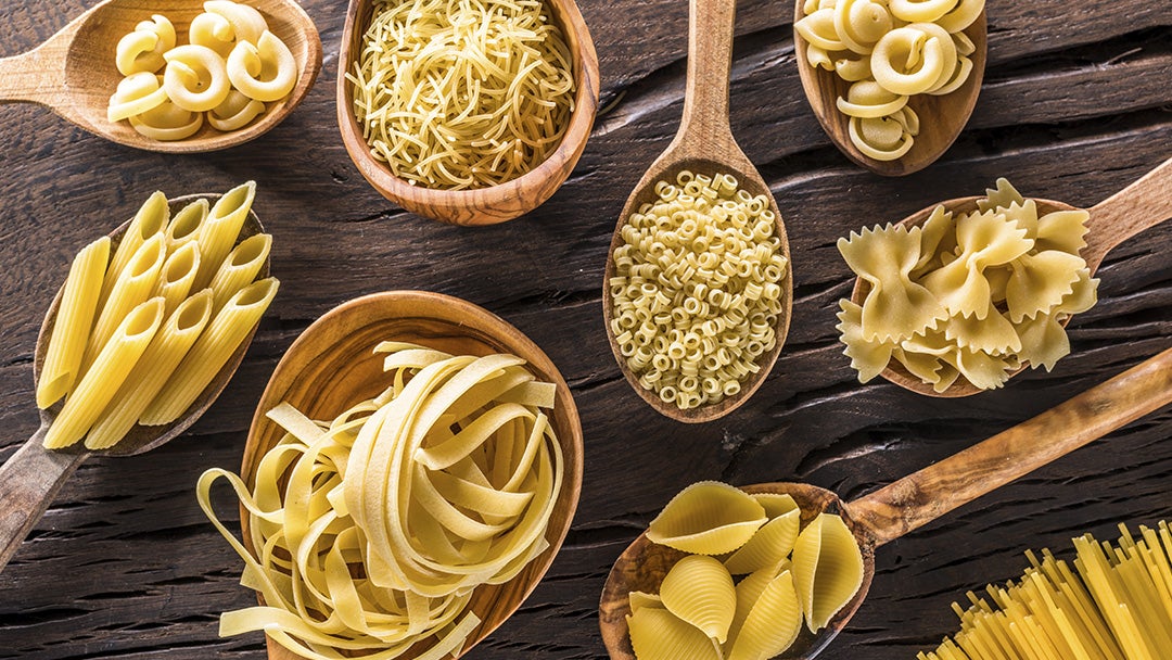Cucharas de madera con distintos tipos de pasta cruda en su interior