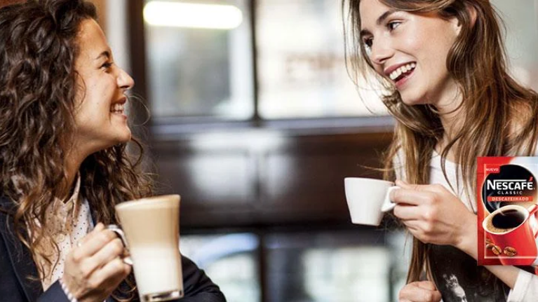 Foto chicas sonriendo con sobres de Nescafé