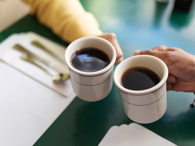 Dos personas tomando café en la oficina
