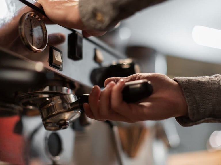 Camarero preparando café en una cafetera profesional