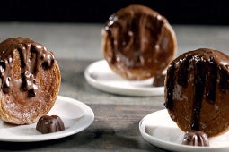 Cinnamon rolls recién horneados y dorados, cubiertos con Untable de Caja Roja fundido